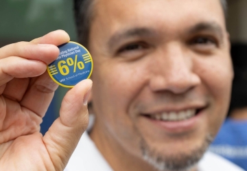 Jose Mayorga, MD, holding a pin from National Latinx Physician Day