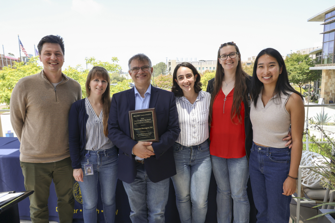 Marangoni stands holding his award with five members of his lab.